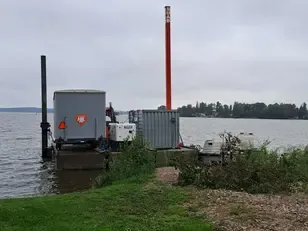 Arbetsplattform med containrar på sjön, med utrustning för arbete med sjöledning.